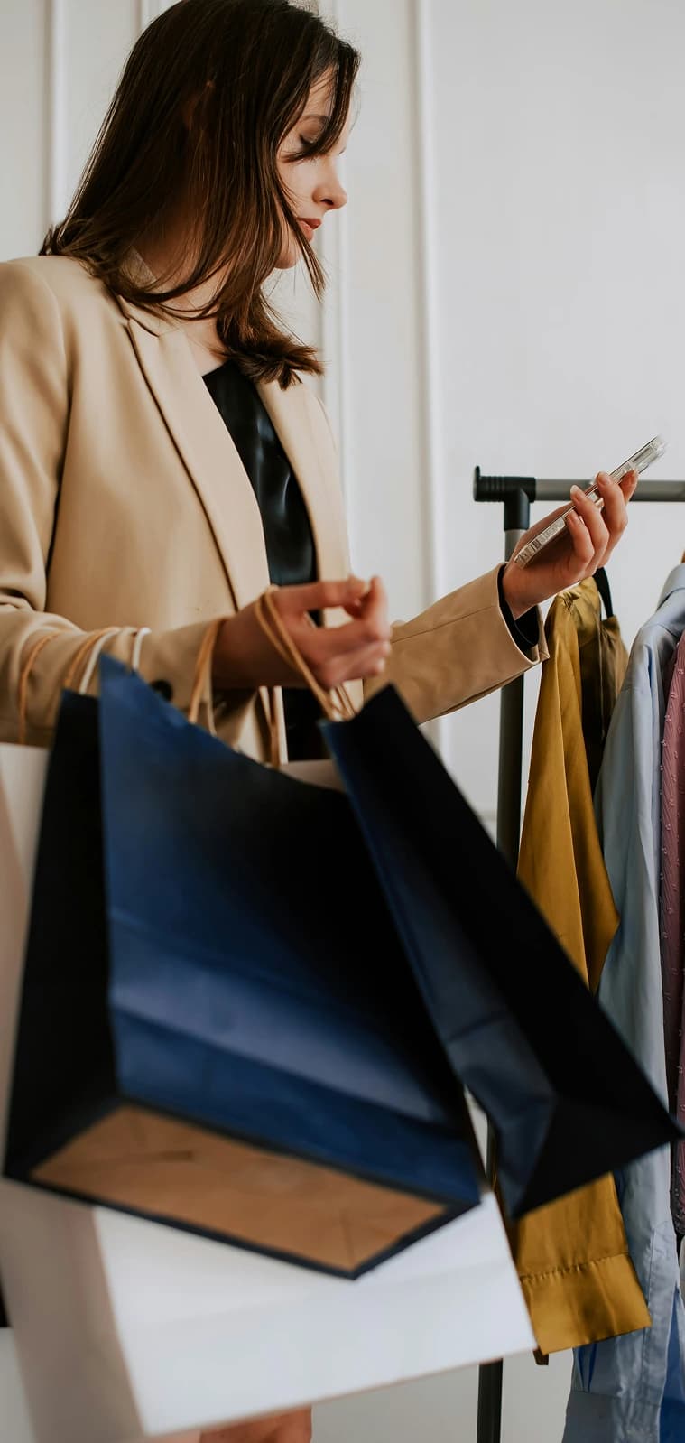 A shopper holding bags while checking her phone